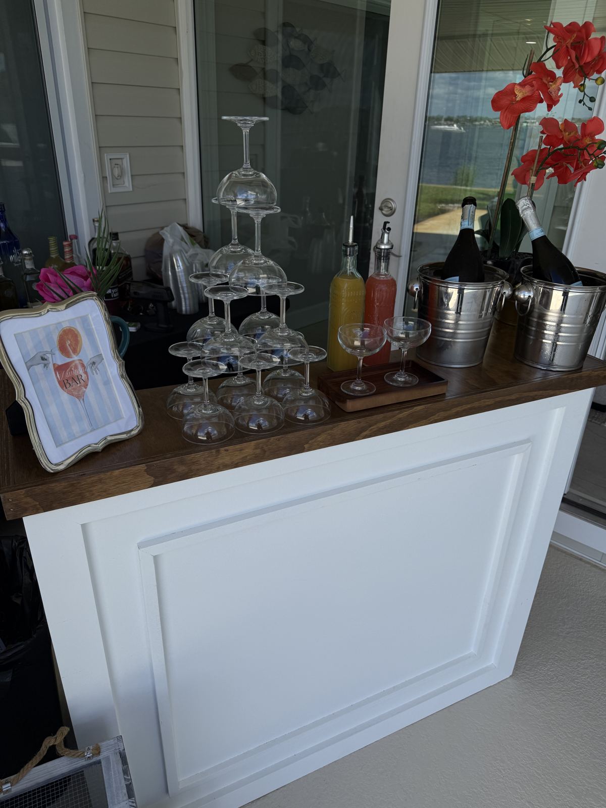 With A Twist mimosa bar setup with glass coupe tower, prosecco in ice buckets, and fresh juices